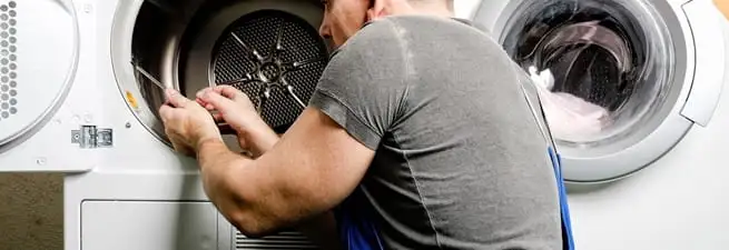 Dryer repair technician fixing a clothes dryer drum in Portland, OR