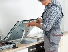Appliance repair technician installing a built-in cooktop in Portland, OR