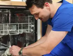 Dishwasher repair technician inspecting and servicing an open dishwasher in Portland, OR