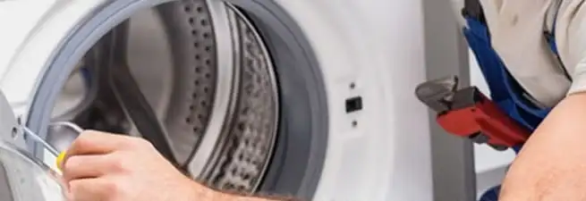 Appliance technician repairing a clothes dryer drum and internal parts in Portland, OR
