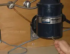 Garbage disposal repair technician tightening the mounting ring under a sink in Portland, OR