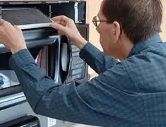 Appliance repair technician replacing a microwave vent filter in Portland, OR