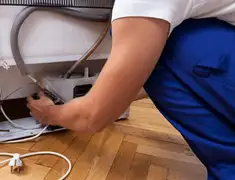 Appliance repair technician fixing refrigerator water line and connections in Portland, OR