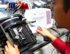 Vacuum repair technician servicing internal components on a workbench in Portland, OR