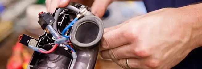Vacuum repair technician reconnecting wiring and components in Portland, OR