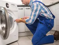 Washing machine repair technician servicing a front-load washer in Portland, OR
