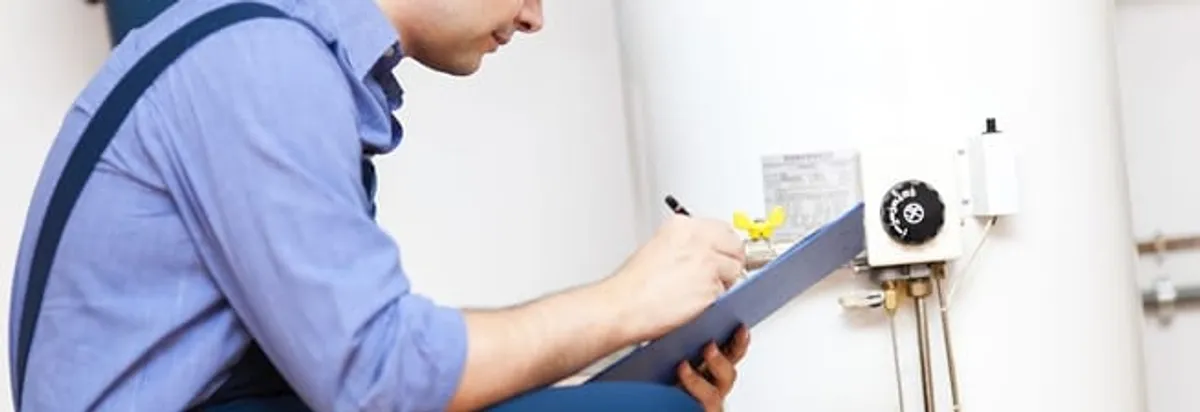 Water heater repair technician inspecting the unit and recording service notes in Portland, OR