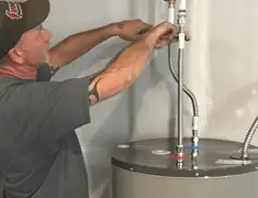 Water heater repair technician tightening supply line connections in Portland, OR
